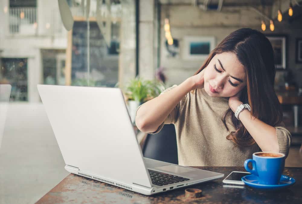 woman sitting with neck pain discomfort